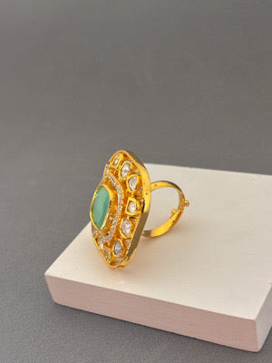 Gold Ring with Green Gemstone and Intricate Detailing