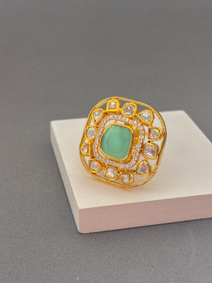 Gold Ring with Green Gemstone and Intricate Detailing