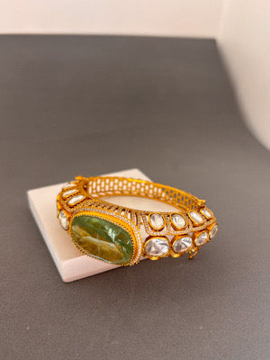 Elegant Gold Bracelet with Green Gemstone and Clear Stone Accents